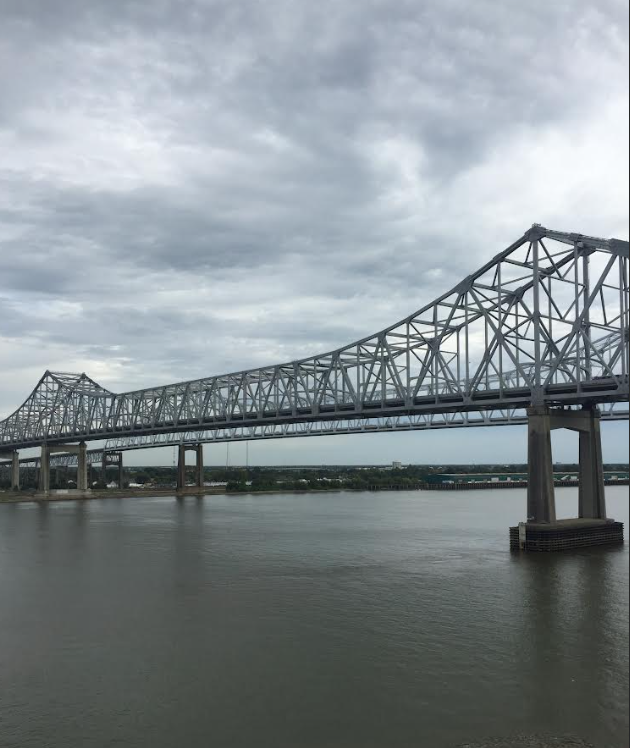 A steel truss bridge over water under a gray sky.
